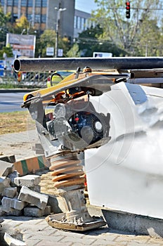 Plate compactor at a construction site.