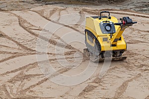 Plate compactor at a construction site.