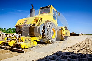 Plate compactor is mounted on road roller to compact soil at construction site