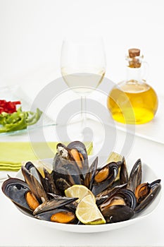 Plate of coocked mussels with lemon isolated over white photo