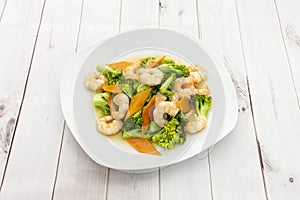 Plate of cooked peeled prawns with broccoli al dente and carrot slices