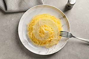 Plate of cooked spaghetti squash on gray background