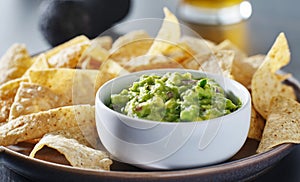 Plate of corn tortilla chips with guacamole dip