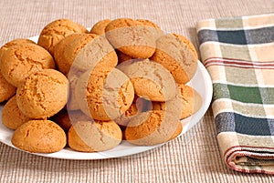 Plate of crisp Italian Amaretti cookies with a checkered napkin
