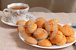 Plate of crisp Italian Amaretti cookies with a cup of hot tea in
