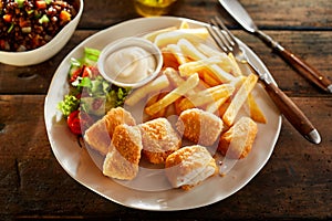 Plate of crispy golden kibbeling with French Fries