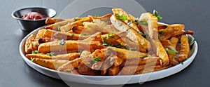 Plate of crispy seasoned french fries with parsley garnish