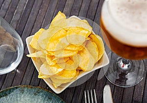 Potato chips served with glass of beer