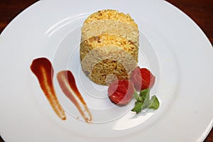Plate of Cup rice decoration with tomato sauce and make tomato flower on white plate on table