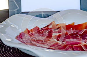 Plate with cut slices of jamon serrano, traditional Spanish ham