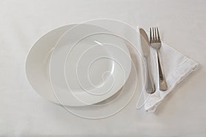 Plate, cutlery set and napkin on table