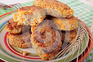 Plate with cutlets of barley porridge with carrots and onions