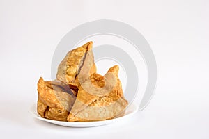 Plate with deep fried Samosas on white