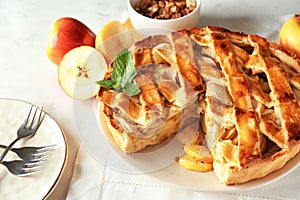 Plate with delicious apple pie on white table, closeup