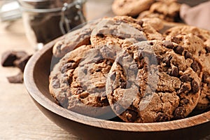 Plate with delicious chocolate chip cookies on wooden table, closeup