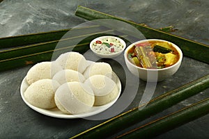 Plate of delicious iddly with sambar ,chutney.