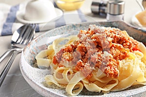 Plate with delicious pasta bolognese on table