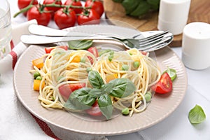 Plate of delicious pasta primavera served on white table, closeup