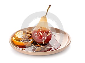 Plate with delicious poached pear in red wine on white background