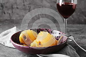 Plate with delicious poached pears in wine on grey table