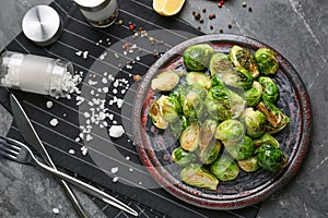 Plate with delicious roasted Brussels sprouts on table, top view