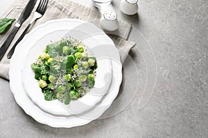 Plate of delicious salad with Brussels sprouts on grey table, top view.