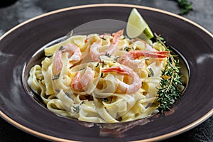 A plate of delicious shrimp alfredo with garlic and cream sauce over fettuccine pasta. Italian food, top view. Food recipe