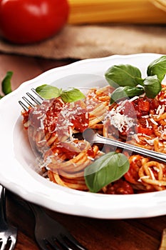 Plate of delicious spaghetti Bolognaise or Bolognese with savory minced beef and tomato sauce garnished with parmesan