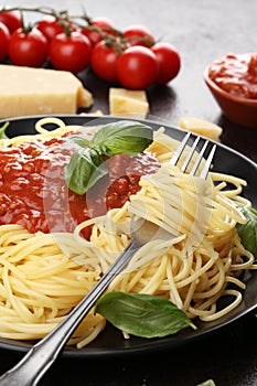 Plate of delicious spaghetti Bolognaise or Bolognese with savory minced beef and tomato sauce garnished with parmesan