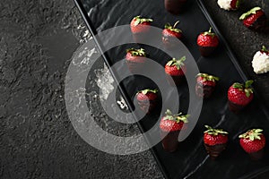 Plate with delicious strawberry covered with chocolate on grey textured background