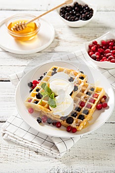 Plate with delicious waffles with berries and ice cream