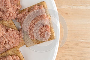 Plate of deviled ham on crackers.
