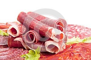 Plate with different meat delicacies isolated on white background. Shallow depth of field