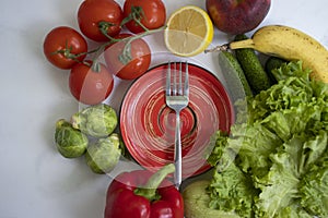 Plate of different vegetables and fruits lettuce on a light background