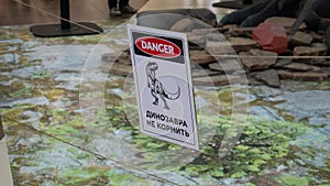 A plate with a dinosau danger zone , do not enter