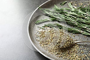 Plate with dried rosemary and twigs on table,