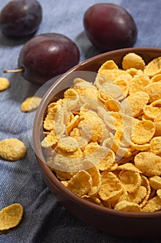 A plate of dry cornflakes on the table with fruit. Morning breakfast