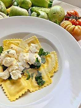plate with egg ravioli pasta, ravioli with crumbled mozzarella, plate with Italian dish