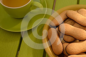 Plate filled with Cat Tongues biscuits, Cup of tea.