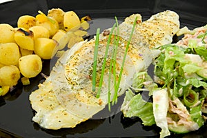 Plate with fish, potatoes and lettuce