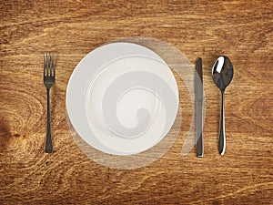 Plate and flatware on wooden table photo