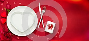 Plate, fork, knife and roses on red cover