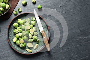 Plate with fresh Brussels sprouts on table, top view.