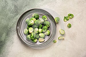 Plate with fresh brussels sprouts on table, top view