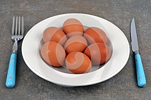 Plate of fresh chicken eggs in a plate with cutlery close-up