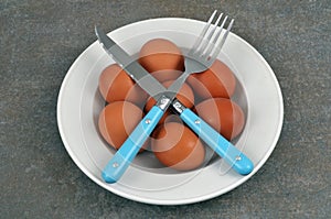 Plate of fresh chicken eggs in a plate with cutlery close-up