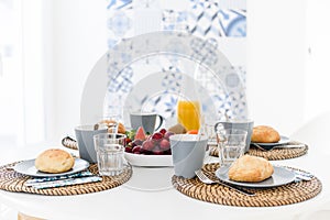 Plate with fresh crusty bread and glass of juice on grey plate