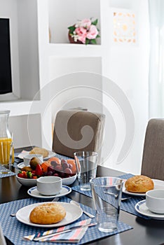 Plate with fresh crusty bread and glass of juice on grey plate