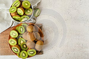 Plate with fresh cut kiwi on light background