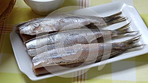 Plate with fresh Dutch raw herring close up